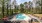 pool with reclining seats and lush landscaping